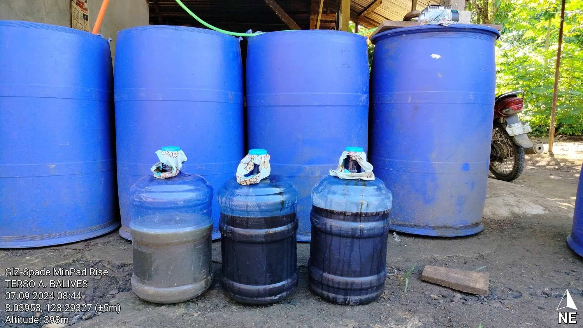 Blue barrels and jugs used for bio-compost preparation at the demo farm